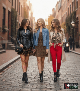Three fashionable women walking arm-in-arm down a cobblestone street, modeling trendy fall outfits featuring leopard prints. The looks include a black leather jacket with a mini skirt, a denim jacket over a dress, and a beige trench coat paired with red pants.